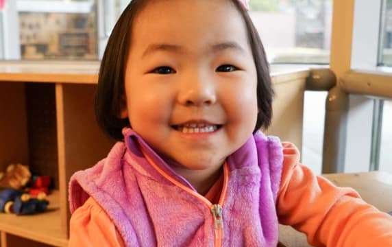 young-girl-smiles-in-classroom